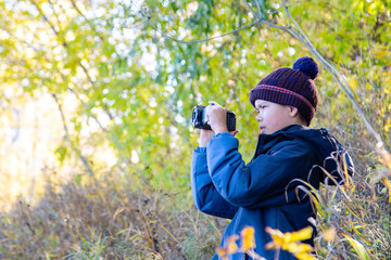 young videographer filming autumn nature