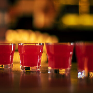 red vodka shots on wooden table square