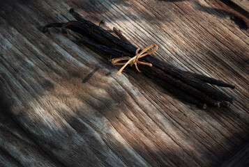 Vanilla dried pods on an old wood background.