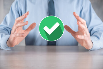 Hand holds green icon Check mark,Check Mark Sign, Tick Icon,right sign,circle green checkmark button,Done.On dark background.Banner.Copy space.Place for text.