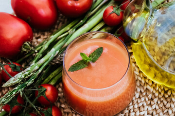 Tomato soup or gazpacho, fresh vegetables on rustic background. Summer cold vegetarian food in Spain.