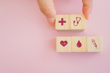 senior's hand holding wooden with health and medical icon on sweet pink background
