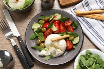 Delicious burrata salad served on wooden table, flat lay