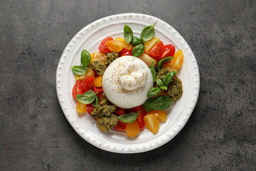 Delicious burrata salad on grey table, top view