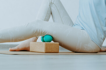 Hamstrings myofascial release massage with therapy balls on cork block. Concept: self care practices at home, knee pain relief