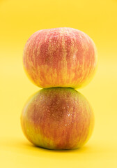 red apple with drop of water isolate on yellow background