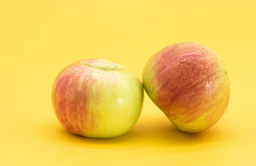 fresh apple with drop of water isolate on yellow background