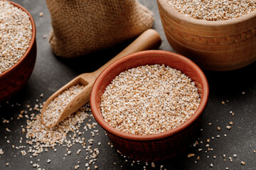 Barley groats in bowls and bags on a dark background. High quality photo