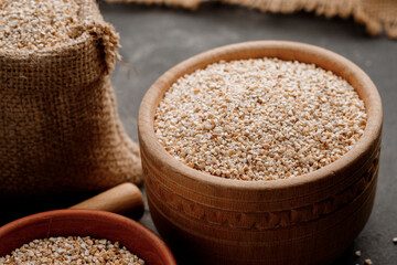 Barley groats in bowls and bags on a dark background. High quality photo