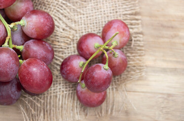 Red grape isolated on wooden background.