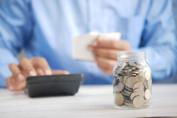 young man saving coins in a jar white sited