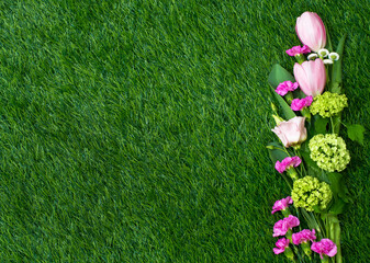 Kwiaty na trawie, różowe kwiaty, kompozycja na zielonym tle