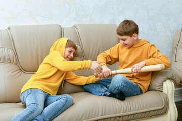 Two boys are sitting on the couch and fighting. Fight and quarre