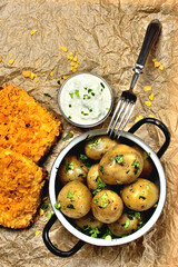 Healthy meal. Mozzarella wrapped in cornflake, boiled potatoes greased with butter and herbs and a healthy yogurt garlic dip. Healthy lifestyle food. Top view. Vertical photo.