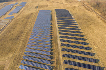 Farma paneli solarnych na równinie pokrytej suchą żółtą trawą. - 494682503