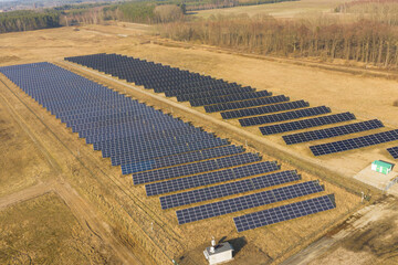 Farma paneli solarnych na równinie pokrytej suchą żółtą trawą. - 494682511