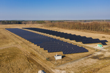 Farma paneli solarnych na równinie pokrytej suchą żółtą trawą. - 494682512