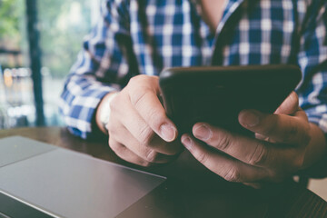 Close up hands of man handsome using smart phone in coffee shop cafe.