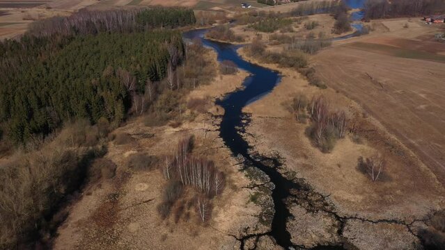 Aerial view of Daugyvene river and Raudondvaris village in early spring.