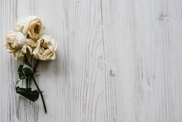 Bouquet of dried flowers. Flowers composition made of dried rose on white wooden background. Flat lay, top view, copy space. Place for text and design.