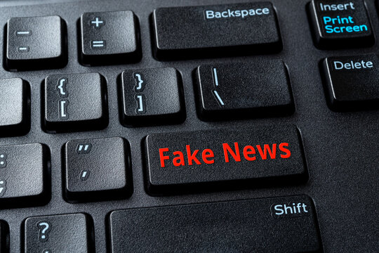 Fake News enter key on the black pc keyboard. Spread false information in the media concept. Propaganda, manipulation and hoax on the Internet. Computer enter key with warning message.