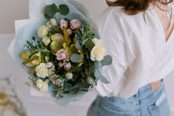 Beautiful bouquet of fresh flowers in female hands. The concept of a festive mood in women