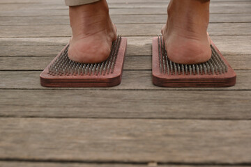 The practice of self-knowledge in the park. A woman with a pedicure stands on sharp nails. Female...