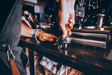 Barista making coffee with coffee machine in cafe.