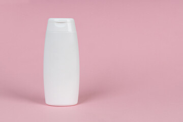 White container of cosmetics on pink background. Skincare product set. Face and body care concept.