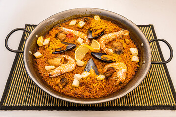 Valencian seafood paella with golden rice in a paella pan