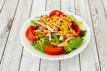 This mixed salad is made up of romaine lettuce, tomato, carrot, surimi, onion, sweet corn, and boiled egg.