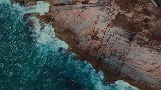 Movement and splash of waves against the rocks. Figure of man. View from the sky. High quality FullHD footage