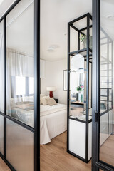 Bedroom with king size bed and black metal shelf with sink and mirror