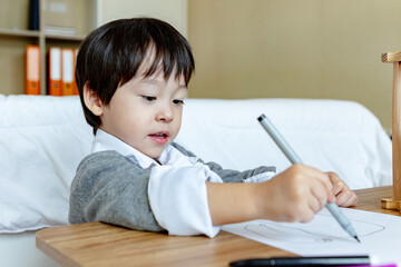 Happy asian little boy on bed.