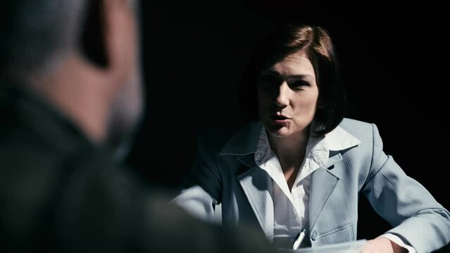 Female police detective showing evidence bag to suspect in custody, questioning