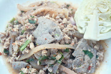 Thai spicy chop pork and slice liver with skin salad eat couple fresh cabbage on plate