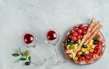 Antipasto platter set on gray concrete background. Overhead, copy space.