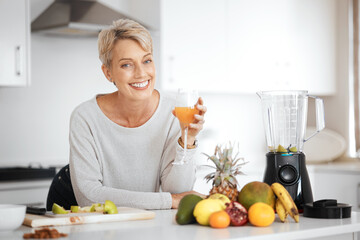 A healthy diet reflects on the outside. Shot of a woman holding a glass of juice in her kitchen.