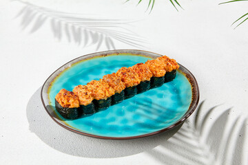 Set of baked gunkan on ceramic plate in minimal style. Hot gunkan sushi assorted with fish, crab, eel, tuna, shrimp and sea scallop. Simple sushi set on white background with hard shadows.