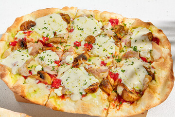 Roman pizza in summer style. Modern pinsa with mushrooms on white background. Roman pizza with mushrooms, ham, tomato sauce and mozzarella cheese