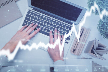 Double exposure of woman hands working on computer and forex graph hologram drawing. Top View. Financial analysis concept.