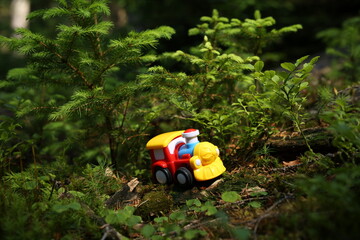 Toy train among young trees in the forest