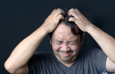 Middle age man has itching in his hair on black background, - obrazy, fototapety, plakaty