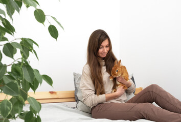 Attractive caucasian brunette young woman,girl with long hair holding,playing with cute little...