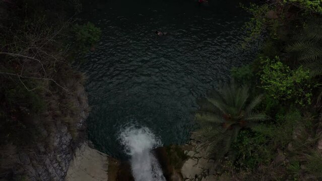 Aerial view of a water flowing into the river in between the mountains 