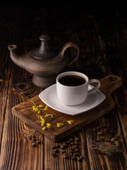 cup of black coffee with coffee beans on wooden background.