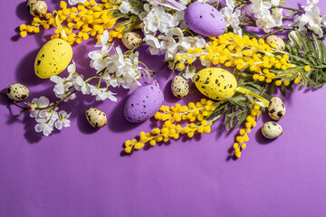 Spring composition with flowers, pastel eggs on purple very peri background. Happy Easter