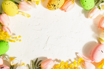 Spring Easter festive background with pastel eggs and traditional spring flowers.