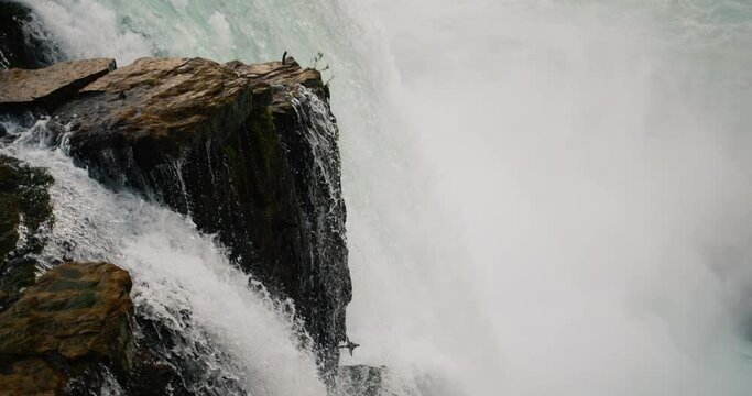 The flow of water of Niagara Falls is trying to crush the rock protruding into the water