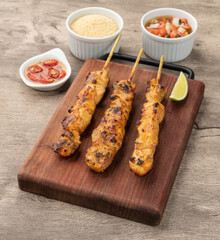 Chicken skewers over wooden board with farofa and vinaigrette